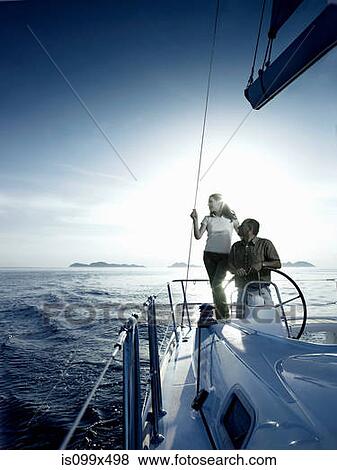 Couple steering a yacht View Large Photo Image Stock Photo - Couple steering a yacht. Fotosearch