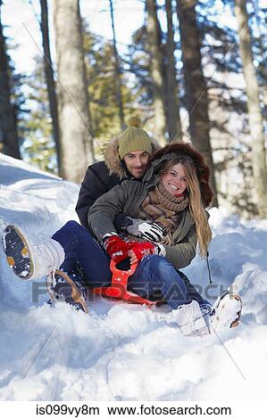 Couple tobogganing in snow View Large Photo Image Picture - Couple tobogganing in snow. Fotosearch