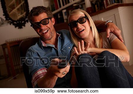 Couple wearing 3d glasses watching tv View Large Photo Image Stock Photography - Couple wearing 3d glasses watching tv. Fotosearch
