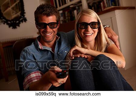 Couple wearing 3d glasses watching tv View Large Photo Image Stock Photography - Couple wearing 3d glasses watching tv. Fotosearch
