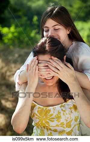 Daughter covering mothers eyes View Large Photo Image Picture - Daughter covering mothers eyes. Fotosearch