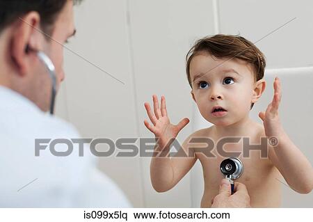 Doctor using stethoscope to check little boy View Large Photo Image Stock Photography - Doctor using stethoscope to check little boy. Fotosearch