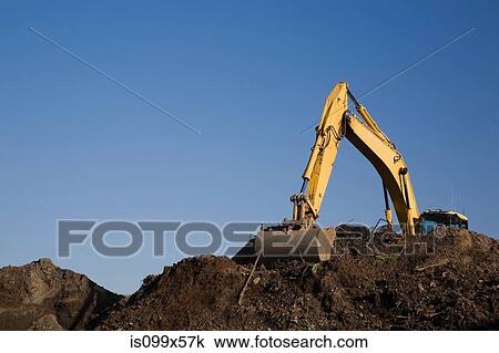 Excavator working on pile of topsoil View Large Photo Image Stock Image - Excavator working on pile of topsoil. Fotosearch