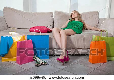 Stock Image - Exhausted young woman with shopping bags. Fotosearch