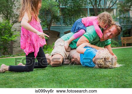 Stock Photography - Father playing with his daughters in garden. Fotosearch
