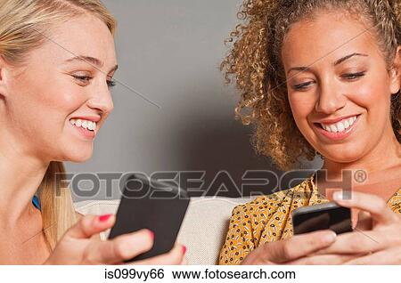 Friends holding cell phones View Large Photo Image Stock Photograph - Friends holding cell phones. Fotosearch