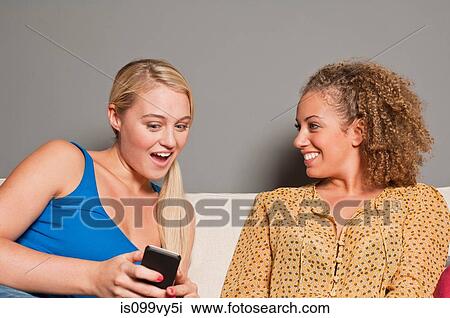 Friends looking at cell phone View Large Photo Image Stock Image - Friends looking at cell phone. Fotosearch