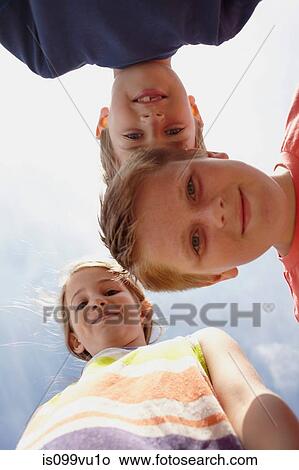 Girl and two boys looking at camera, viewed from below View Large Photo Image Picture - Girl and two boys looking at camera, viewed from below. Fotosearch