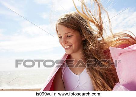 Stock Photography - Girl by the sea wearing a towel, wind in her hair. Fotosearch