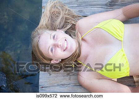 Girl lying on jetty View Large Photo Image Stock Image - Girl lying on jetty. Fotosearch