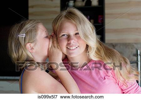 Stock Photo - Girl whispering to friend. Fotosearch