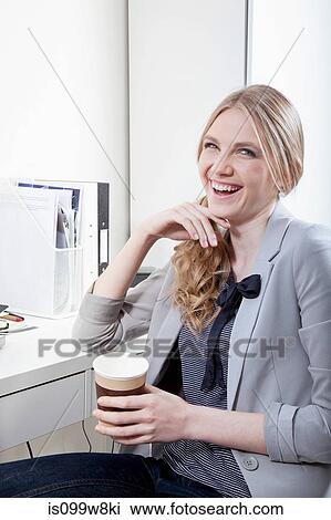 Happy young woman in office with coffee View Large Photo Image Stock Image - Happy young woman in office with coffee. Fotosearch