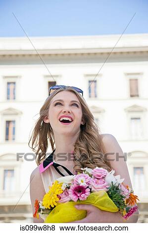 Happy young woman outdoors with bouquet of flowers View Large Photo Image Stock Photo - Happy young woman outdoors with bouquet of flowers. Fotosearch