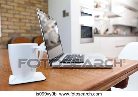 Laptop and mug on table View Large Photo Image Stock Image - Laptop and mug on table. Fotosearch