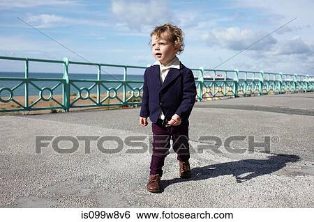 Stock Photograph - Little boy walking promenade in mod clothing. Fotosearch
