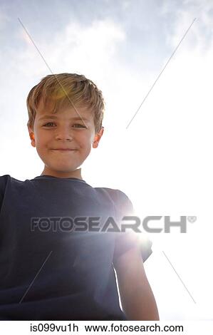 Low angle view of boy in sunlight View Large Photo Image Stock Image - Low angle view of boy in sunlight. Fotosearch