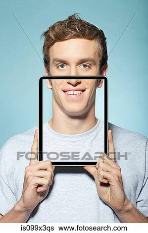 Man covering half his face with digital tablet View Large Photo Image Stock Photograph - Man covering half his face with digital tablet. Fotosearch