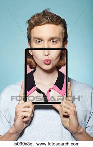 Man covering half his face with digital tablet, with womans mouth View Large Photo Image Stock Photograph - Man covering half his face with digital tablet, with womans mouth. Fotosearch