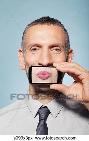 Man covering mouth with smartphone View Large Photo Image Stock Photo - Man covering mouth with smartphone. Fotosearch