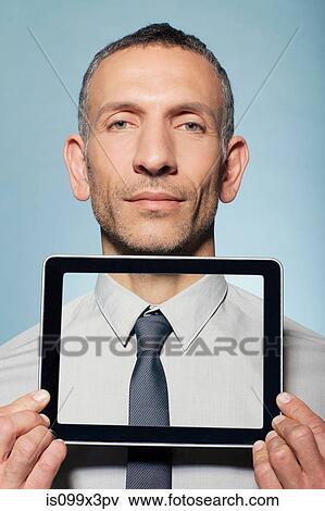 Stock Photo - Man covering neck with digital tablet. Fotosearch