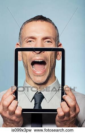 Stock Photo - Man covering neck with digital tablet. Fotosearch