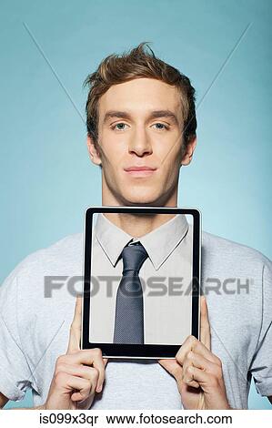 Stock Photography - Man covering neck with digital tablet. Fotosearch