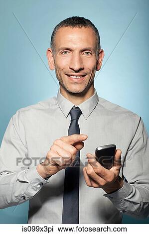 Man holding smartphone View Large Photo Image Stock Image - Man holding smartphone. Fotosearch
