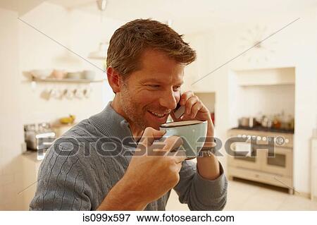 Man on phone drinking coffee View Large Photo Image Stock Photo - Man on phone drinking coffee. Fotosearch