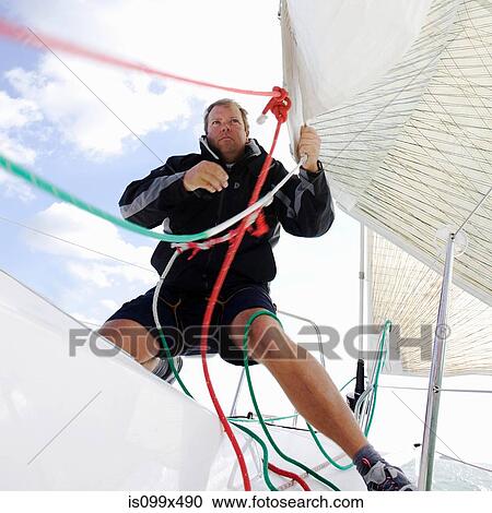 Man on yacht, pulling ropes View Large Photo Image Stock Image - Man on yacht, pulling ropes. Fotosearch