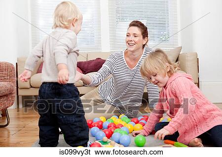 Mother and children playing with plastic balls View Large Photo Image Stock Photograph - Mother and children playing with plastic balls. Fotosearch