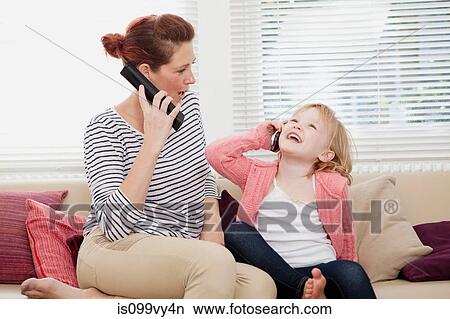 Mother and daughter on cell phones View Large Photo Image Picture - Mother and daughter on cell phones. Fotosearch