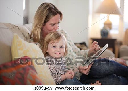 Mother and daughter on sofa with digital tablet View Large Photo Image Stock Photo - Mother and daughter on sofa with digital tablet. Fotosearch