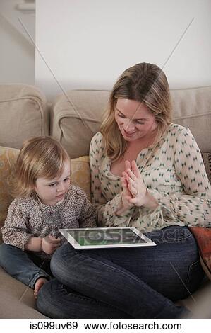 Mother and daughter playing with digital tablet View Large Photo Image Stock Photo - Mother and daughter playing with digital tablet. Fotosearch