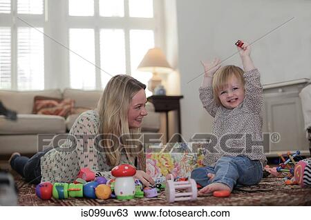 Mother and daughter playing with toys on living room floor View Large Photo Image Stock Image - Mother and daughter playing with toys on living room floor. Fotosearch