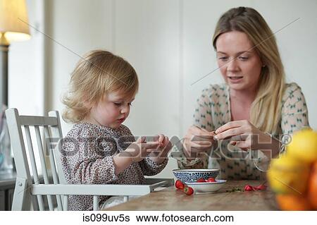 Stock Photograph - Mother and daughter preparing strawberries. Fotosearch
