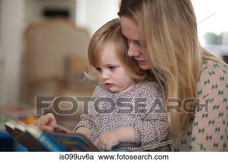 Stock Image - Mother and daughter reading book. Fotosearch