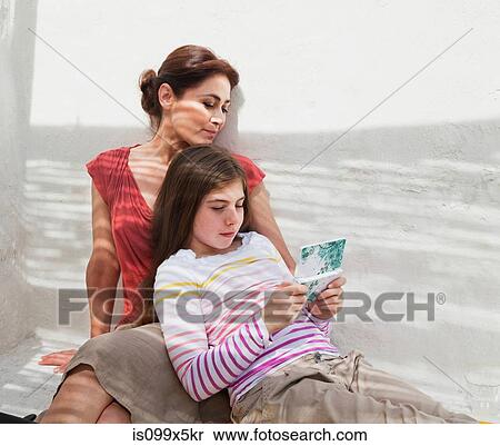 Mother and daughter with hand held device View Large Photo Image Stock Photography - Mother and daughter with hand held device. Fotosearch