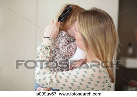 Mother brushing daughters hair View Large Photo Image Stock Photo - Mother brushing daughters hair. Fotosearch