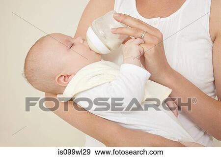 Mother feeding newborn baby bottle of baby milk View Large Photo Image Stock Photo - Mother feeding newborn baby bottle of baby milk. Fotosearch