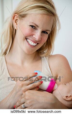 Mother feeding newborn baby boy with bottle View Large Photo Image Stock Image - Mother feeding newborn baby boy with bottle. Fotosearch