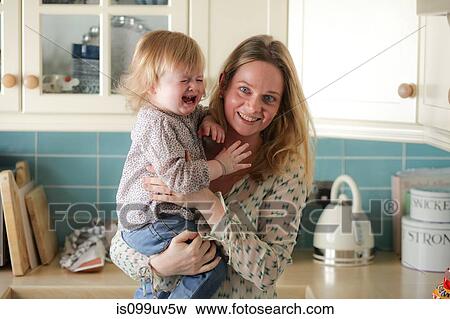 Stock Photo - Mother holding crying daughter. Fotosearch
