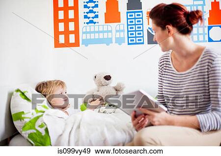 Mother holding digital tablet, daughter in bed View Large Photo Image Stock Photo - Mother holding digital tablet, daughter in bed. Fotosearch