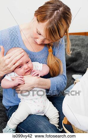Mother holding unwell newborn daughter View Large Photo Image Stock Image - Mother holding unwell newborn daughter. Fotosearch