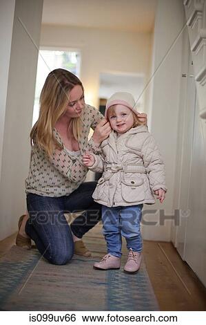 Mother putting knit hat on daughter View Large Photo Image Stock Photograph - Mother putting knit hat on daughter. Fotosearch
