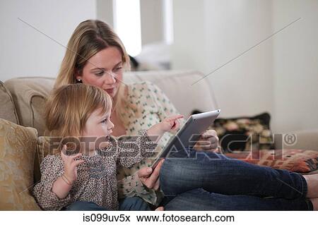 Mother with daughter pointing at digital tablet View Large Photo Image Stock Photo - Mother with daughter pointing at digital tablet. Fotosearch