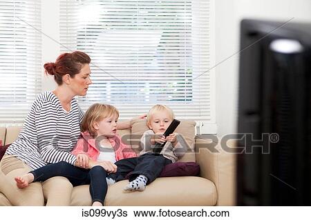 Stock Photograph - Mother with two children watching television. Fotosearch