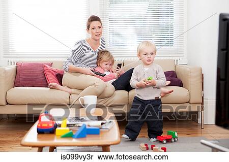 Mother with two children watching television View Large Photo Image Stock Photography - Mother with two children watching television. Fotosearch