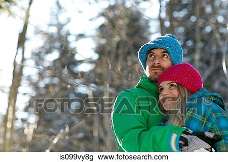 Stock Image - Portrait of couple hugging, wearing winter clothes. Fotosearch