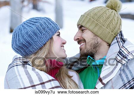 Portrait of couple wearing knit hats, wrapped in blanket View Large Photo Image Stock Photograph - Portrait of couple wearing knit hats, wrapped in blanket. Fotosearch