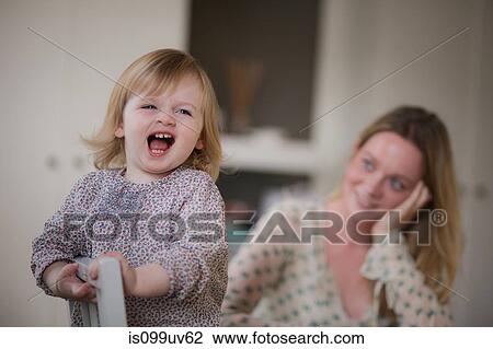 Stock Image - Portrait of mother and daughter smiling. Fotosearch